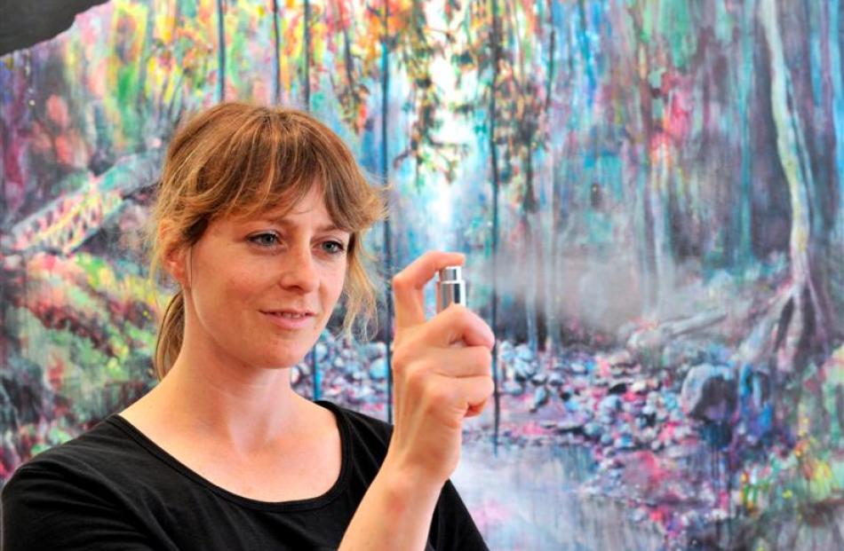 Dunedin artist Anya Sinclair (36) sprays the perfume that inspired  the Never & Forever piece...