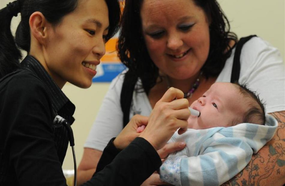 Dunedin Hospital paediatric doctor Mee-Yew Chen (left) demonstrates how a new rotavirus vaccine...