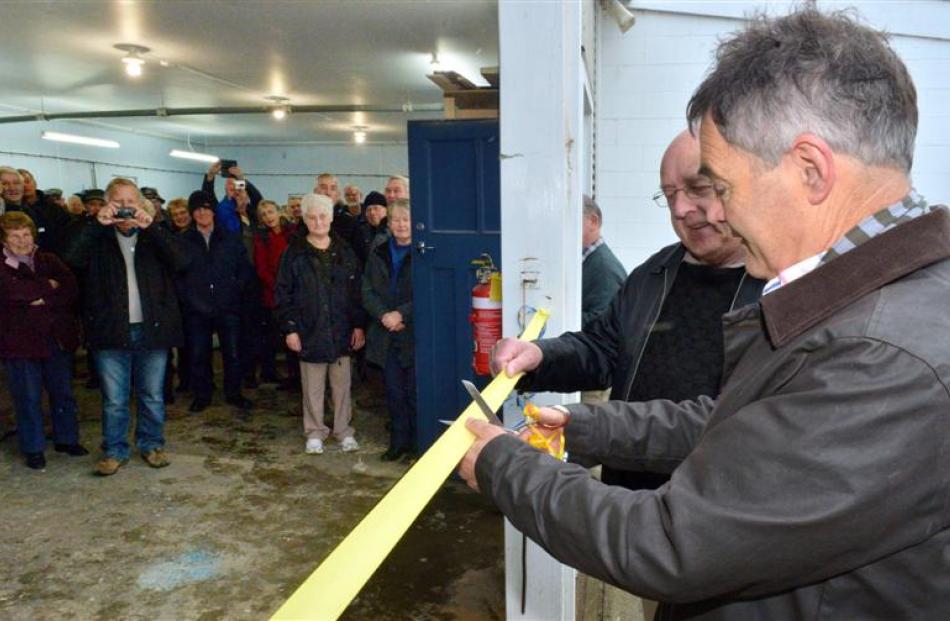 Dunedin Mayor Dave Cull cuts the ribbon to open the new Taieri Blokes' Shed with founding member...