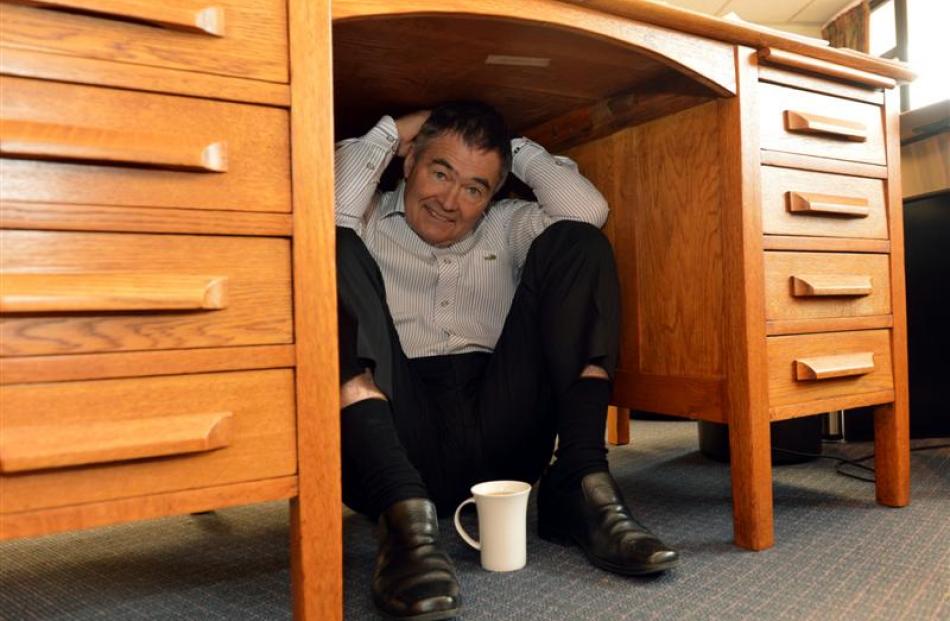 Dunedin Mayor Dave Cull shelters under his desk. Photo by Stephen Jaquiery.