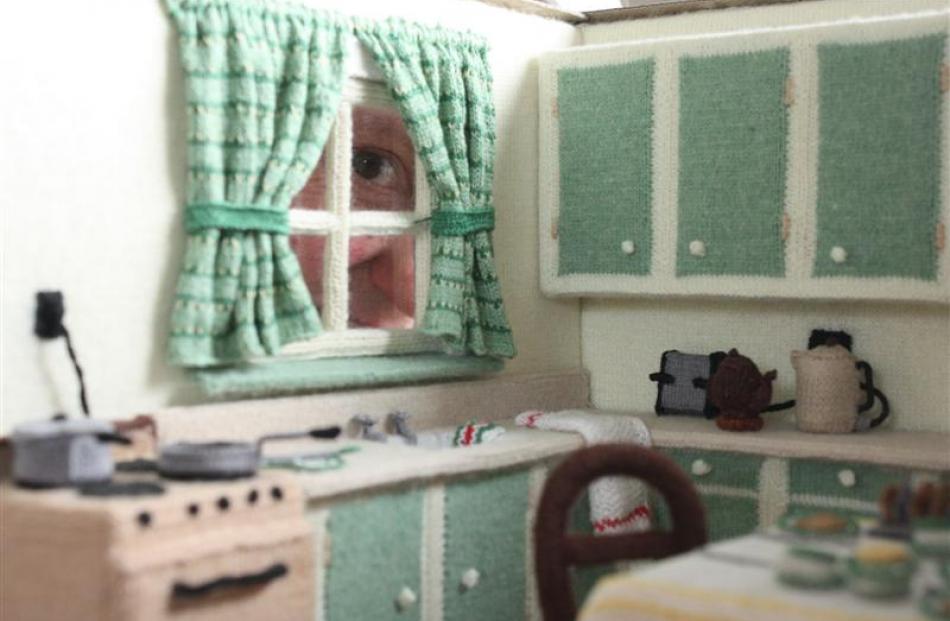 Dunedin Miniaturist Club member Jill York looks through the window of the miniature kitchen she...