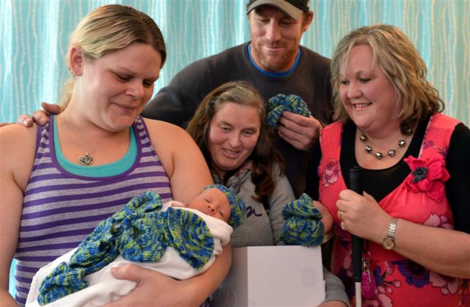 Dunedin mother Kristy Tennison tries a beanie for size on week-old Kaleb Moodie, watched by (from...