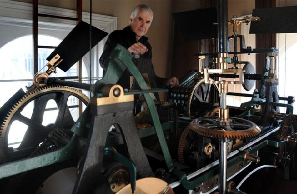 Dunedin Municipal Chambers clock caretaker Jeff Martin inspects the clock's mechanism yesterday....