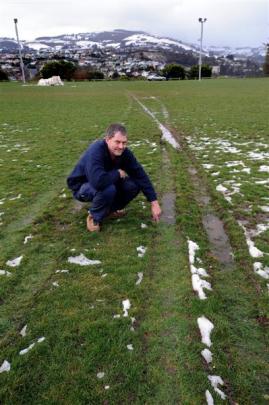 Dunedin resident Doug Pryor inspects some of the damage caused by the driver of a vehicle on...