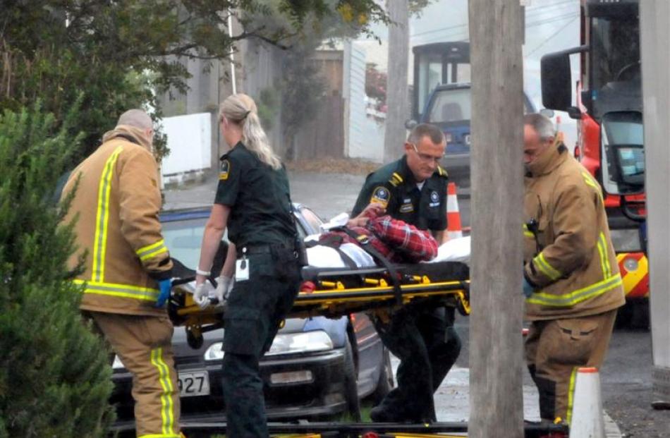 Emergency services assist a burnt man in Dunedin yesterday. Photo by Christine O'Connor.