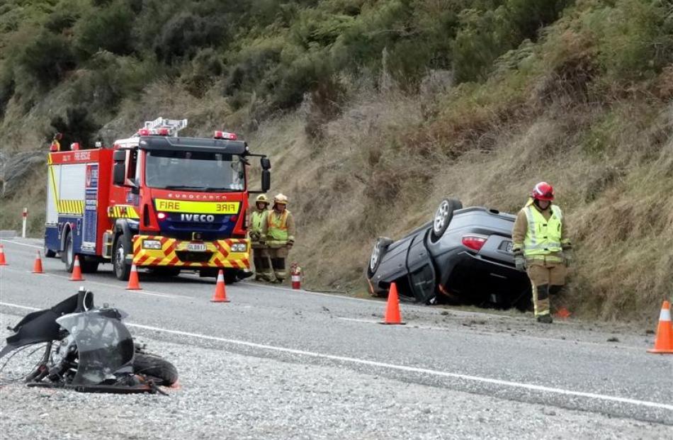 Emergency services personnel attend the scene of the crash on State Highway 6 near the Devils...