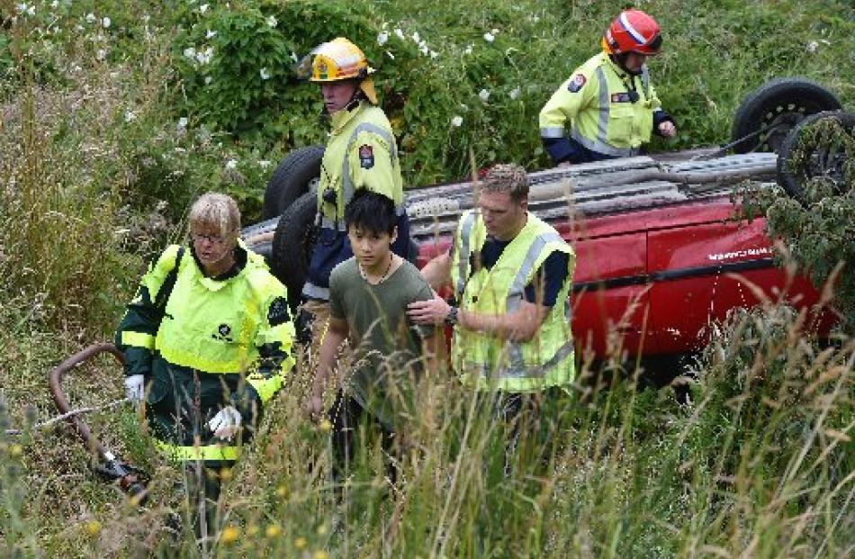 Emergency services staff assist the male driver of a vehicle that rolled in Fea St, Dalmore,...