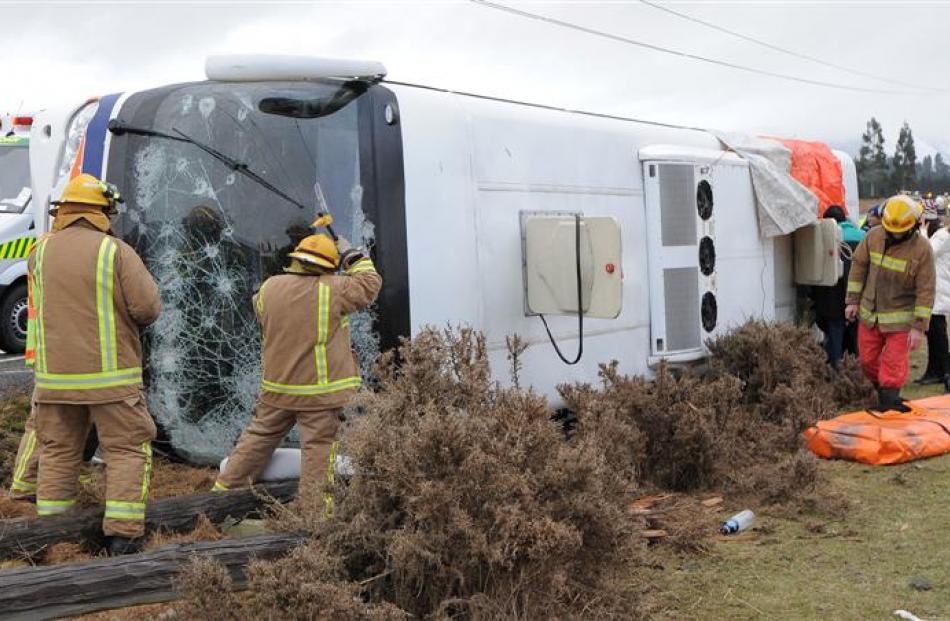 Emergency services work at the scene of yesterday's bus crash on State Highway 94 near Mossburn,...