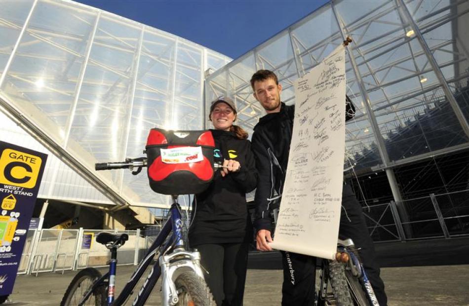 England rugby fans Jodie Burton and Tom Hudson show their "World in Union" scroll outside Otago...