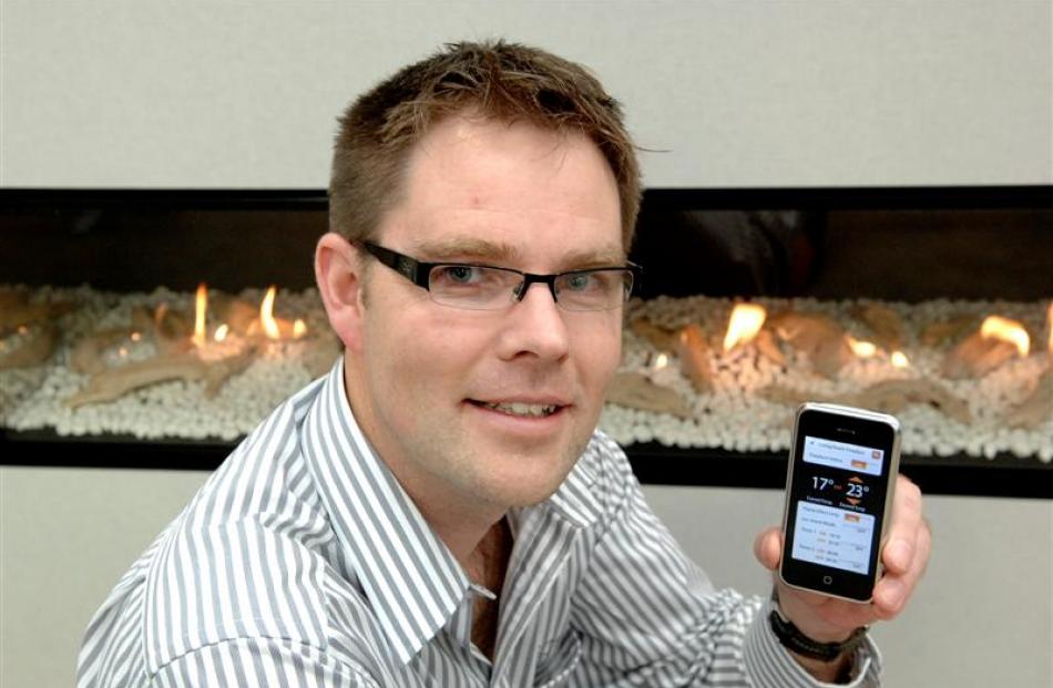 Escea chief executive Nigel Bamford with the iPhone app that controls the new luxury gas...