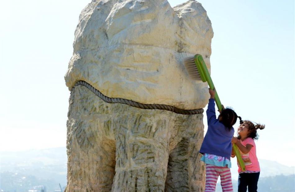 Esther Halalilo (4, left) and Manusiu Pole (3) take a big toothbrush to one of the Harbour Mouth...
