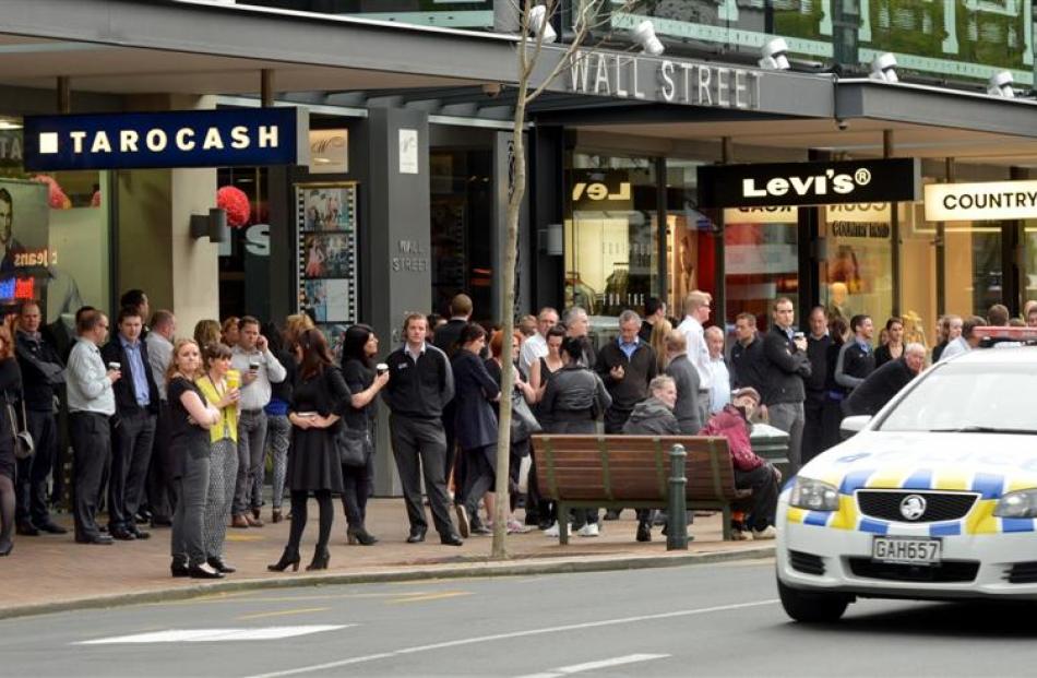 Evacuated workers line George St after a gas leak in Albion Lane yesterday. Photos by Stephen...