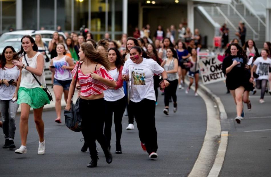 Fans run around Auckland Airport hoping to see One Direction as they fly in from Australia on...