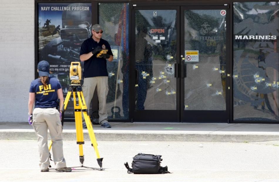 FBI agents continue their investigation at the Armed Forces Career Centre in Chattanooga,...