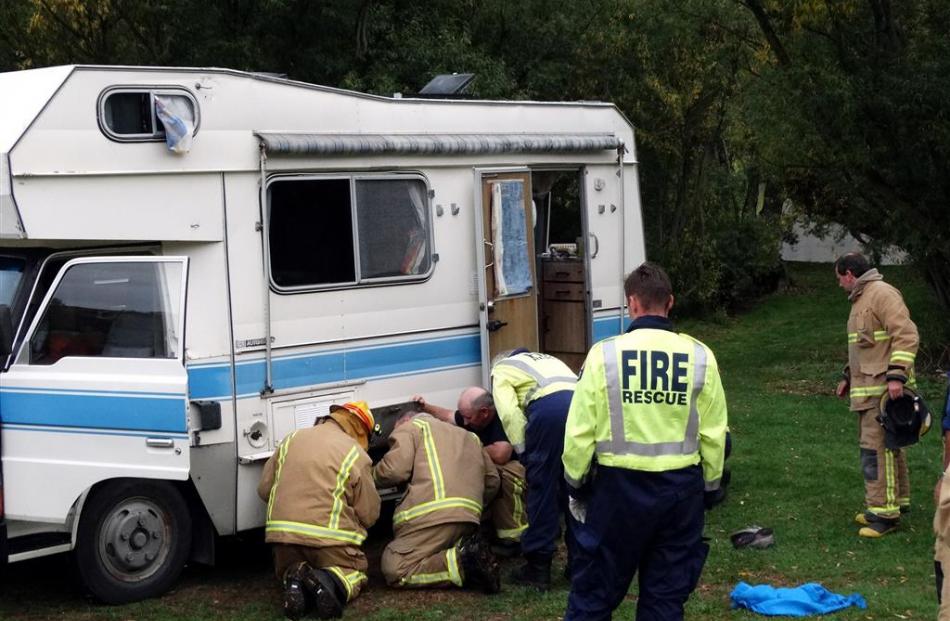 Fire Service personnel check a damaged camper van at the north end of Lake Hayes last night after...