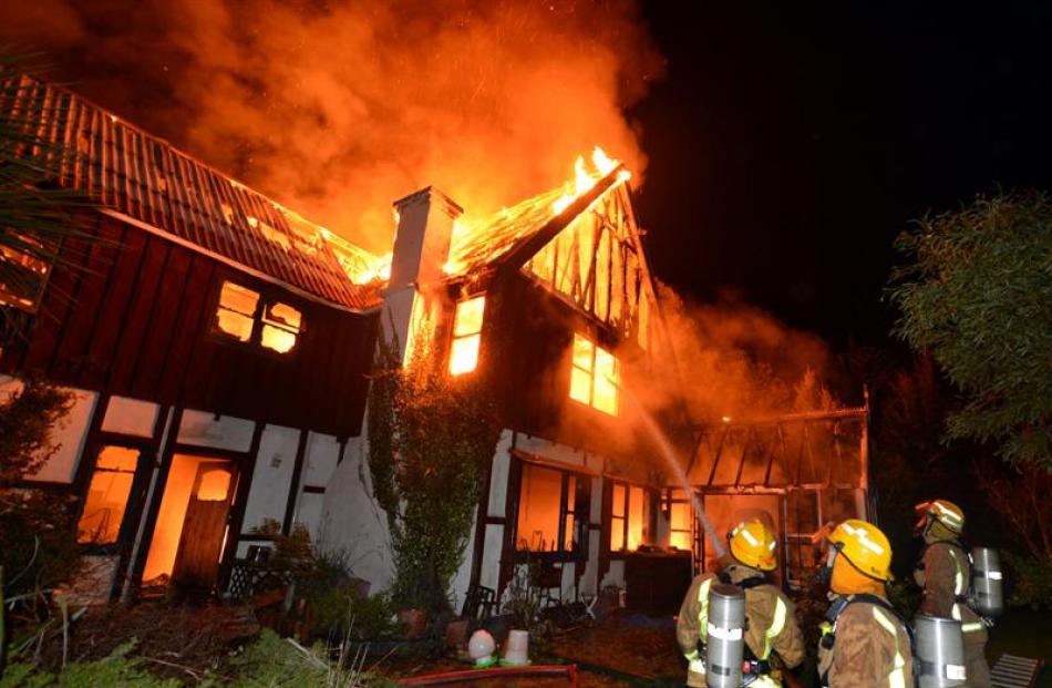 Firefighters battle a house fire in St Leonards Dr, Dunedin, about 3am yesterday. The window from...