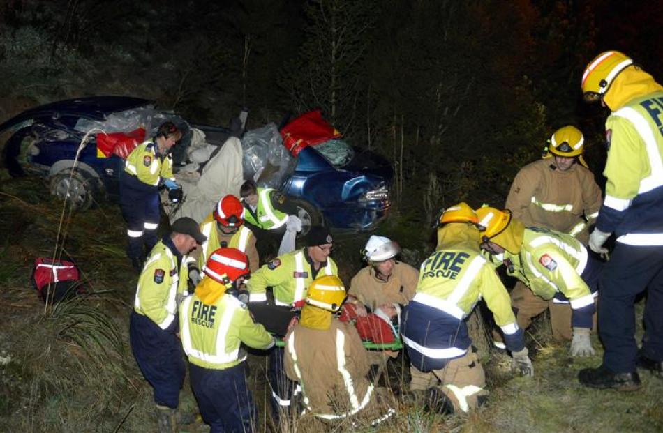 Firefighters help free a female passenger after the car she was in hit black ice yesterday. Photo...