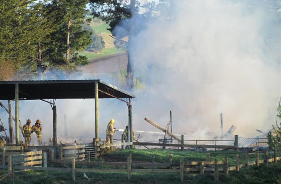 Firefighters pour water on a fire at Enfield, 15km inland from Oamaru, yesterday morning. Photo...