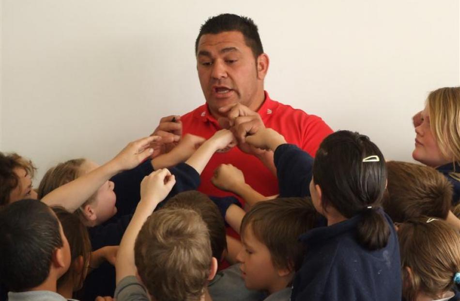 Former All Black Kees Meeuws is surrounded by pupils during a visit to  St Mary's School in...
