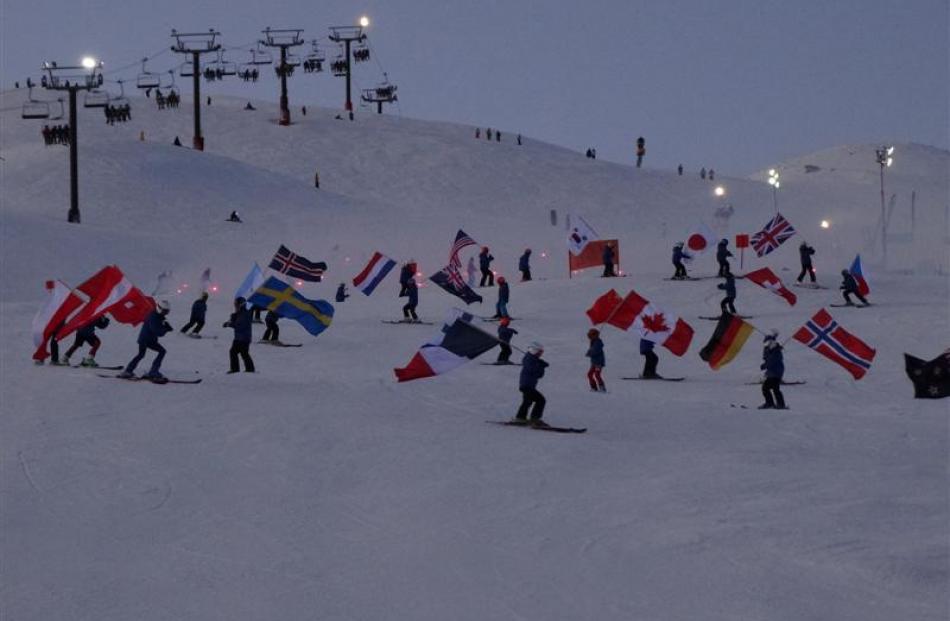 Forty members of the Queenstown Alpine Ski Team, bearing the flags of the countries of the...