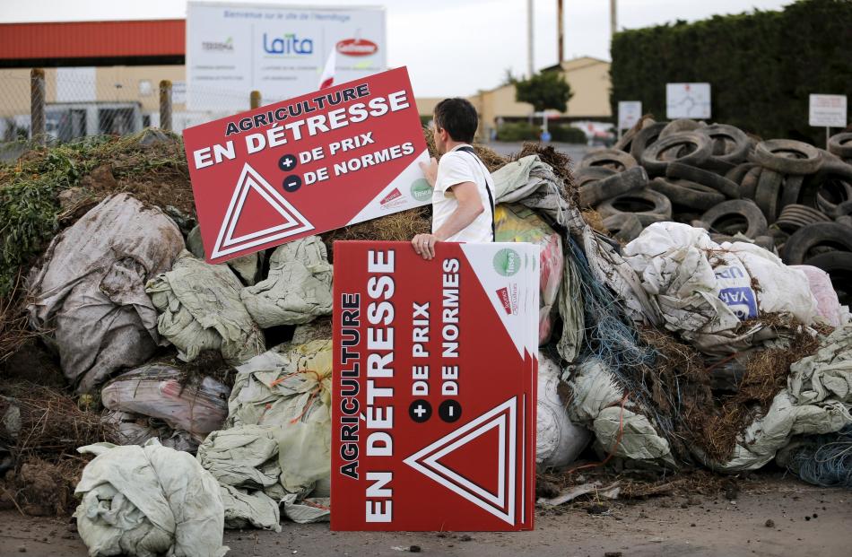 French farmers block the entrance of a dairy in Ancenis, France, during a protest against a...