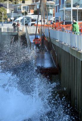 Fulton Hogan contractors use a crane to remove a damaged section of ramp from the Esplanade at St...