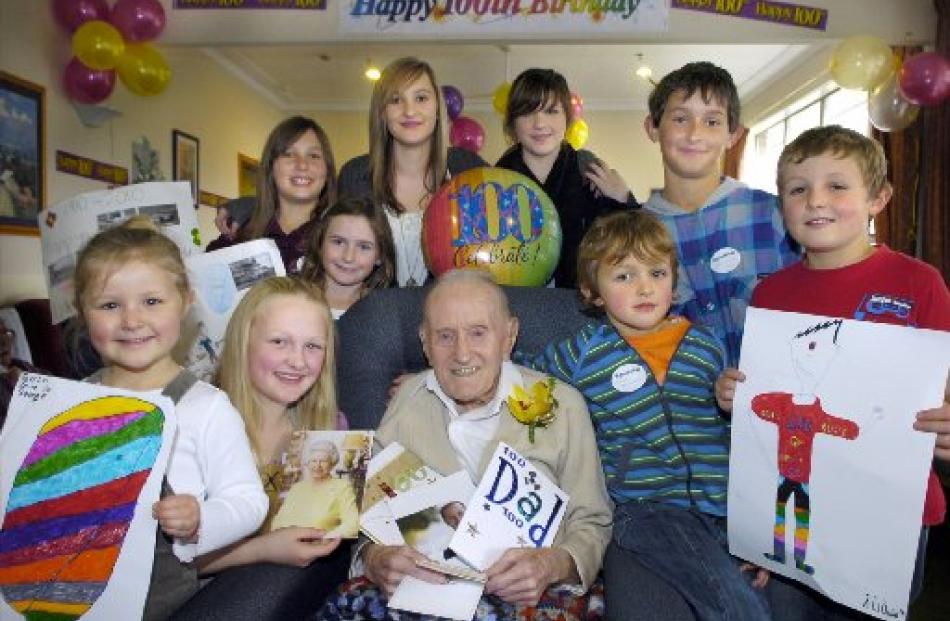 George McKnight celebrates his 100th birthday with great-grandchildren, from left, Farrin Quin (6...