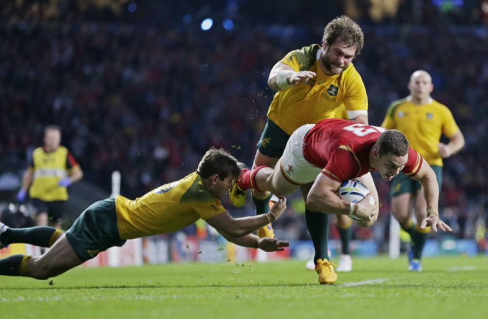 George North is stopped close to the line by some outstanding Australian cover defence. Photo:...