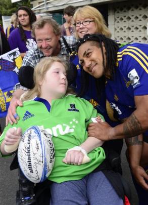 Getting a rugby ball from Highlander Ma'a Nonu is Andrew Easton (17, in wheelchair), with ...