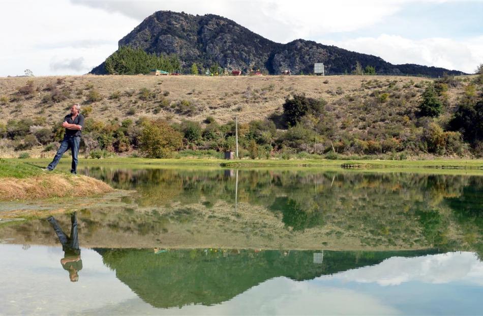 Graham Lee stands beside one of his salmon ponds, in the shadow of Mt Iron. Photos by Stephen...