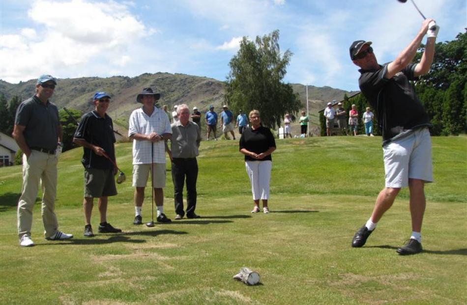 Greg Turner tees off, watched by (from left) Sir Russell Coutts, Kevin Hurley, of Cromwell, club...