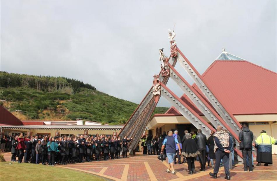 Guests and visitors enter the wharenui at the Te Rau Aroha Marae at the beginning of the Ngai...