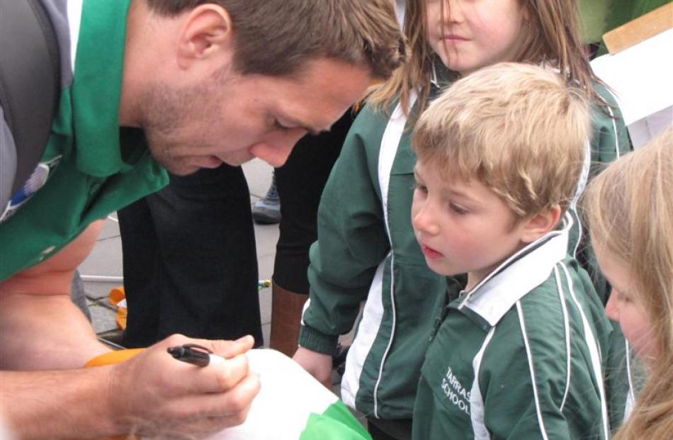 Halfback Isaac Boss, formerly of Hamilton, signs an autograph for Jacob Dennis (5), of Tarras...