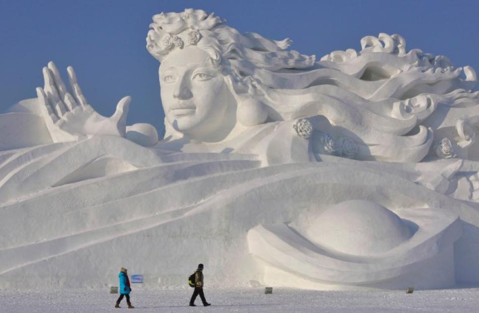 Visitors walk past a giant snow sculpture at the festival. REUTERS/Sheng Li