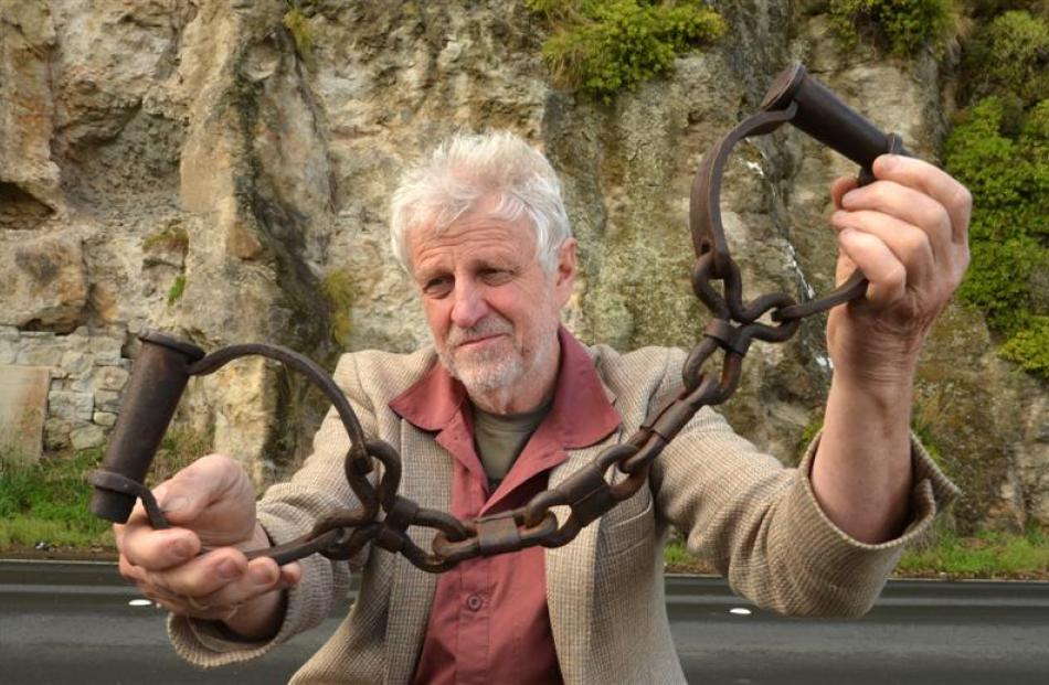 Hayward's Auction House owner Kevin Hayward holds forged leg irons outside the Dunedin cave from...