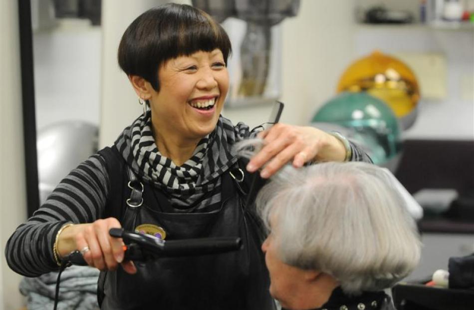 Headquarters Centre City style director Judi Wong puts a curl in the hair of Helen Packer. Photo...