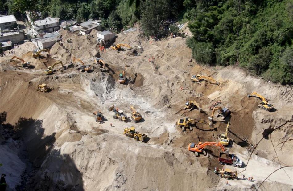 Heavy machinery working at an area affected by a mudslide in Santa Catarina Pinula, on the...
