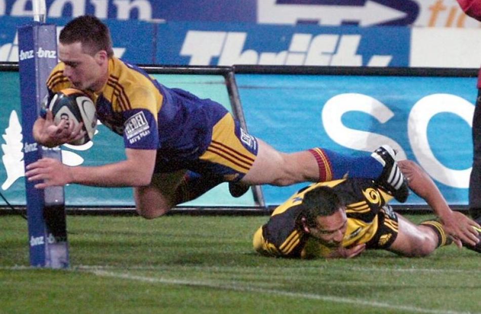 Highlanders winger Ben Smith (yes, that's him) dives over for a try as Hurricanes defender Hosea...