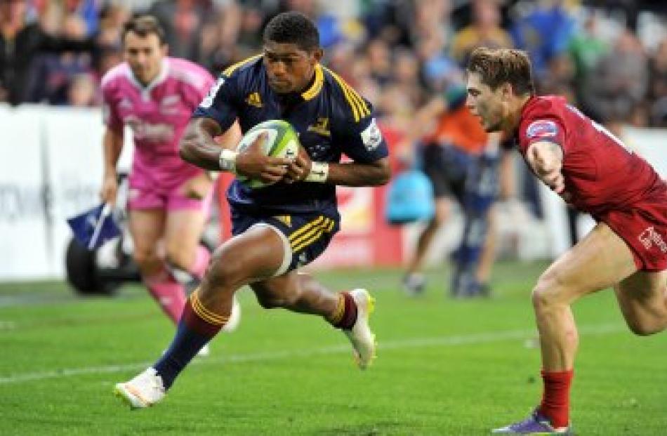 Highlanders winger Waisake Naholo beats Reds fullback Lachie Turner and heads for the tryline....