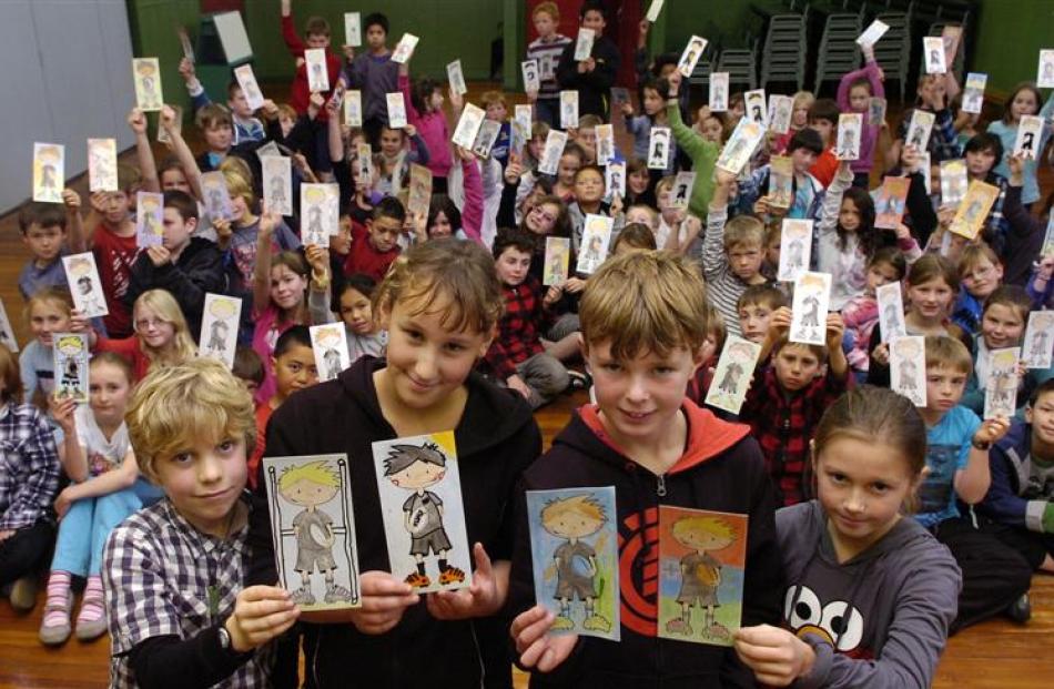 Holding the colourful cutout All Blacks they have coloured in to be sent to schools in Argentina,...