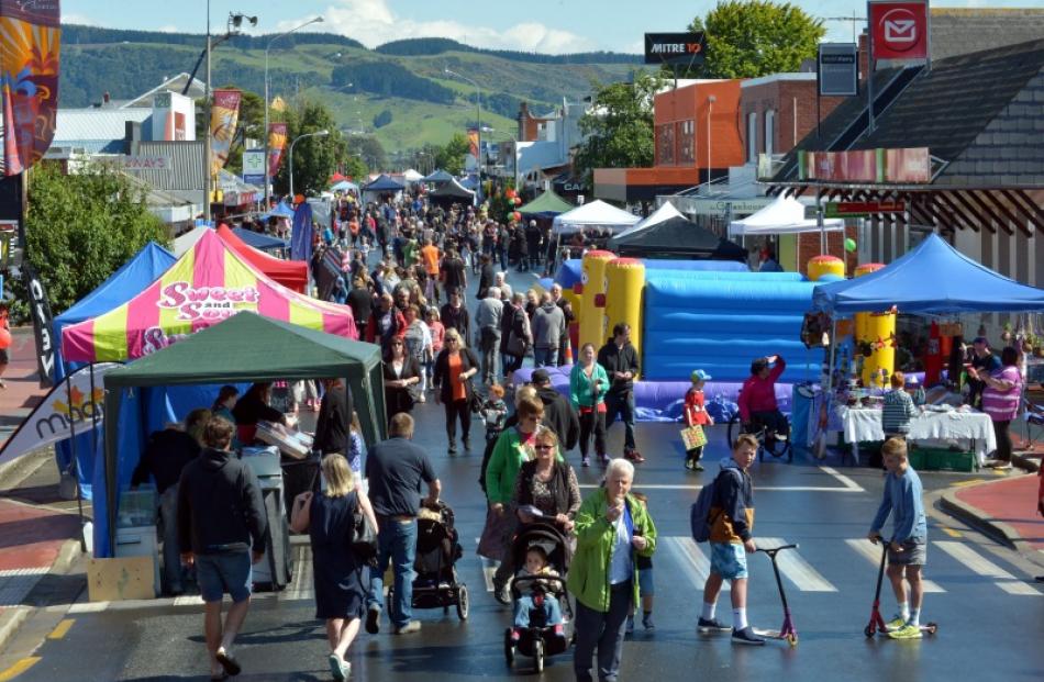 Hundreds of people peruse the stalls at Mosgiel Community Market Day just after the rain clears....