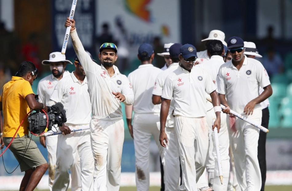 India's captain Virat Kohli (3rd left) shows a stump as he celebrates with his teammates Stuart...