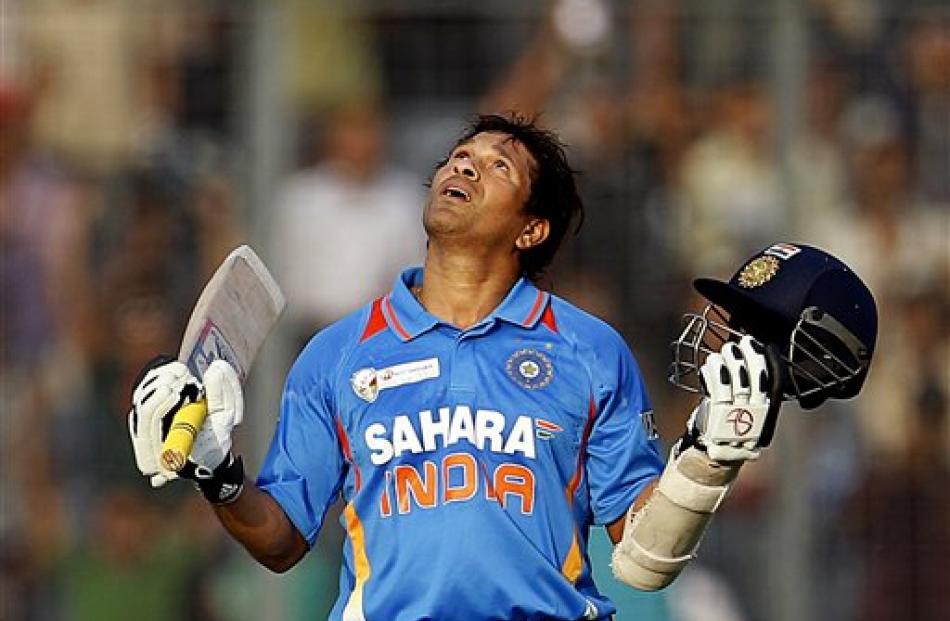 Indian batsman Sachin Tendulkar celebrates scoring his 100th international century during the...