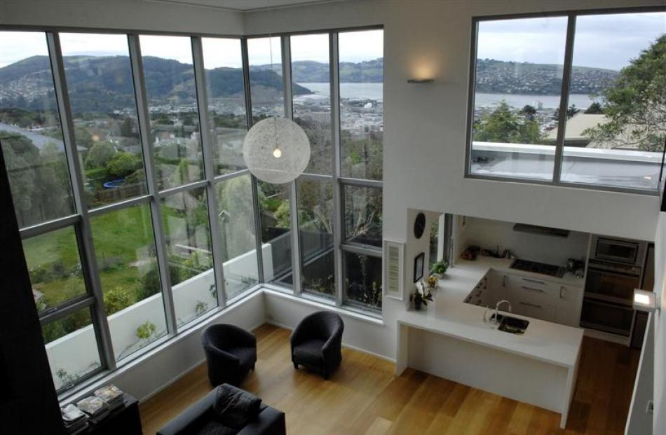 Interior living spaces are organised to make the most of the harbour view. This photo is taken...