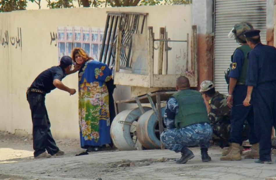 In this photo released by the Iraqi Police, police appear to examine a girl who they suspected of...