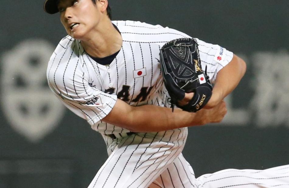 Japan's starter Shohei Otani, who both pitches and hits for the Nippon Ham Fighters, pitches...