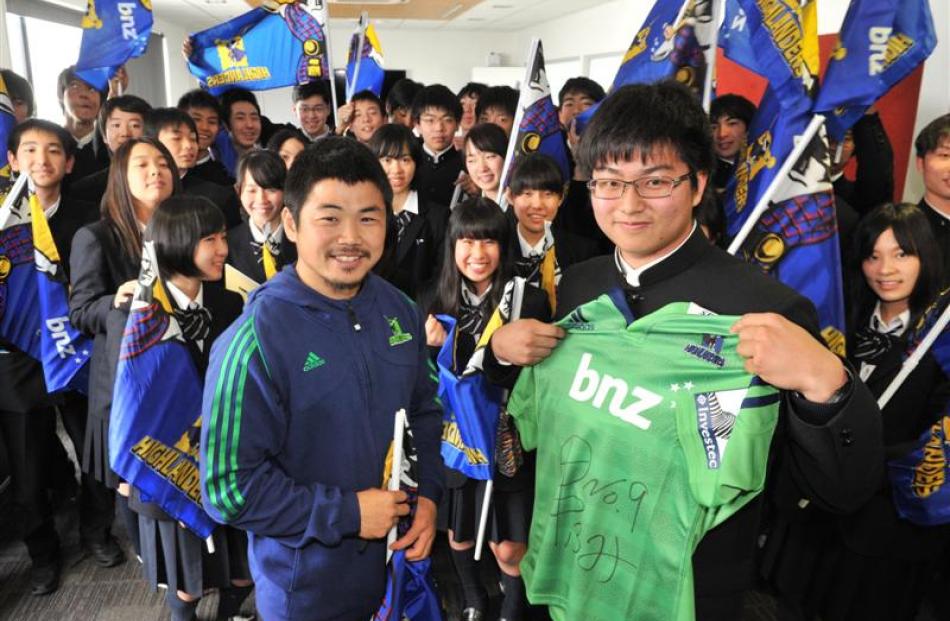 Japanese exchange student Takechika Hayashi (16, right) holds a Highlanders jersey signed by team...