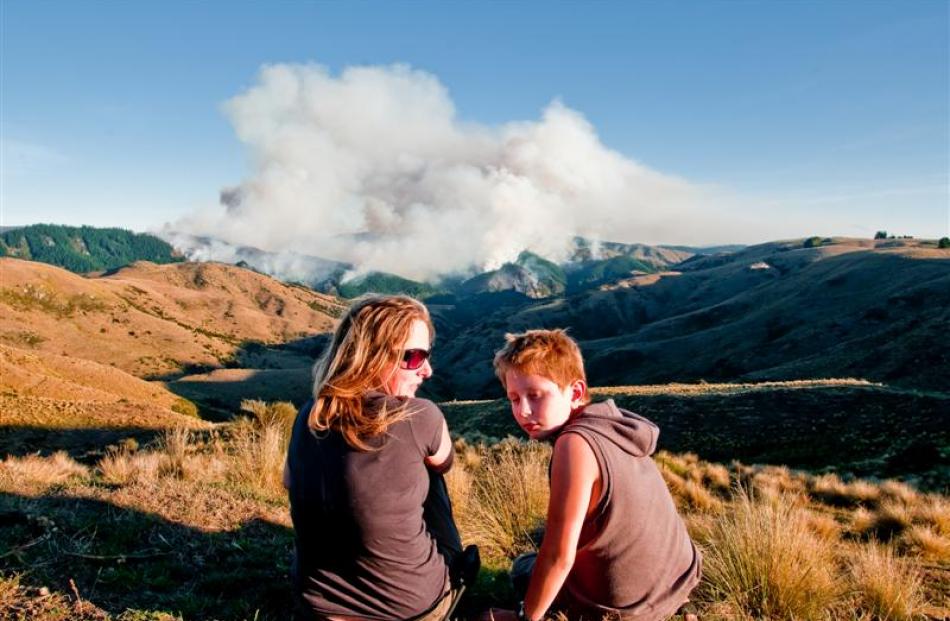 Jeannine Falloon and Daniel Dickson watch the fire from their neighbouring property yesterday....
