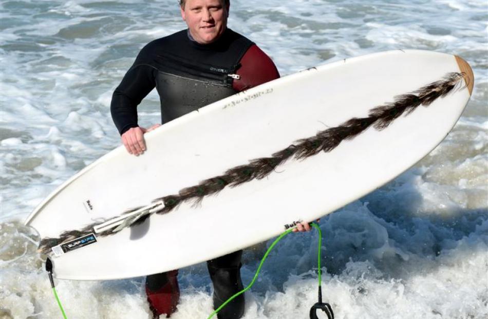 Jeremy Buis, of Dunedin, is a convert to Surfsafe - a shark-repellent device retrofitted to...