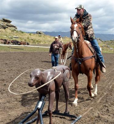 Jerrad Hofstetter watches as Stu Moore, of Roxburgh,  lassoes a practice calf on Dandy. Photo by...